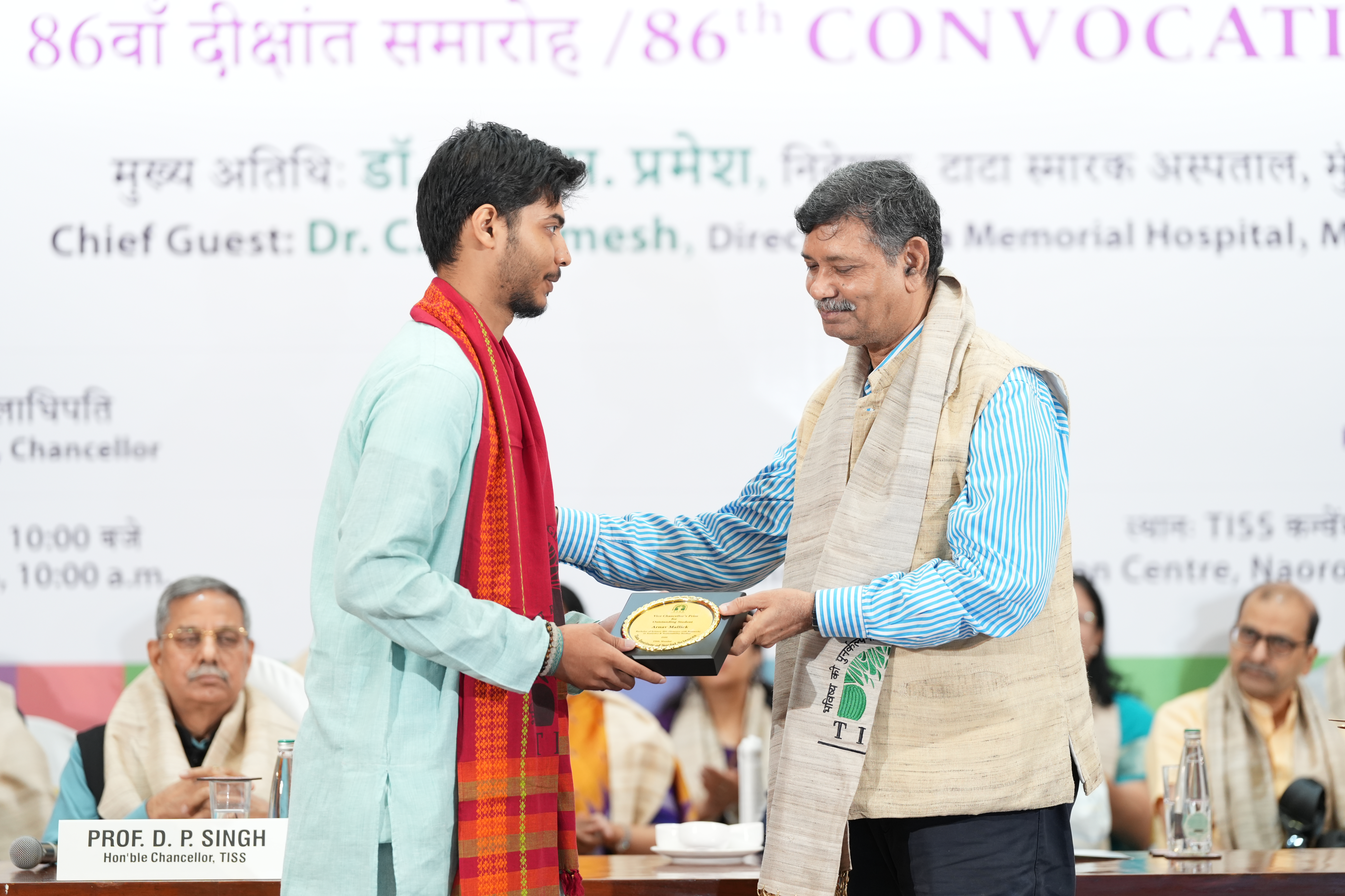 Students in academic regalia receiving awards on stage